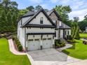 Charming home with landscaped lawn, two-car garage, and stone and white painted brick facade at 9713 San Remo Pl, Wake Forest, NC 27587