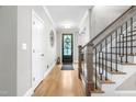 Inviting home foyer with hardwood floors, paneled front door, and staircase to the second floor at 9713 San Remo Pl, Wake Forest, NC 27587