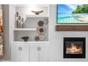 Stylish living room featuring built-in shelves, a shiplap wall, a cozy fireplace, and a flat screen television at 9713 San Remo Pl, Wake Forest, NC 27587