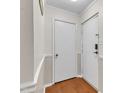 Hallway featuring two white doors with traditional trim and wood floors at 1008 Sandlin Pl # J, Raleigh, NC 27606