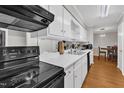Well-lit kitchen featuring white cabinetry and modern black appliances at 1008 Sandlin Pl # J, Raleigh, NC 27606