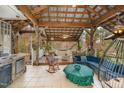 Relaxing outdoor patio area with a wood-beamed roof, comfortable seating, and a charming hammock at 103 Pony Express Cv, Louisburg, NC 27549
