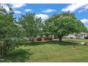Expansive front yard with mature trees and manicured lawn creating a welcoming curb appeal at 105 Poplar Dr. Dr, Clayton, NC 27520