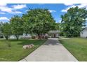 Long driveway leading to a well-kept home with a covered carport and lush green surroundings at 105 Poplar Dr. Dr, Clayton, NC 27520
