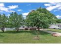 Landscaped front yard featuring mature trees, healthy green lawn, and a charming single-story home at 105 Poplar Dr. Dr, Clayton, NC 27520