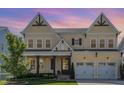Inviting two-story home with a charming front porch and a well-manicured lawn, featuring a two-car garage at 1131 Lowland St, Apex, NC 27523