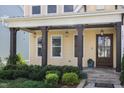 Charming front porch with dark wood columns, beautiful landscaping, and a welcoming wood front door at 1131 Lowland St, Apex, NC 27523