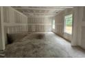 Unfinished living room space illuminated by natural light streaming through the windows at 115 Mildred Place, Broadway, NC 27505