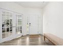 Bright foyer features wood-look floors, a bench, and a doorway with glass french doors at 116 Hayfield Dr, Lillington, NC 27546