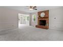 Bright living room features neutral walls, plush carpet, and brick fireplace with hearth and mantle at 1228 Shakentown St, Knightdale, NC 27545
