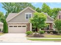 Charming home with stone and shake facade, a well-maintained lawn, and a two-car garage at 125 Greenway Landing Lndg, Chapel Hill, NC 27516