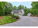 Home with a three-car garage, extra parking space, and well-manicured landscaping in a verdant setting at 1301 King Cross Ct, Raleigh, NC 27614