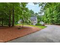 Inviting home with attached garage, long driveway, and well-maintained lawn in a picturesque, wooded area at 1301 King Cross Ct, Raleigh, NC 27614