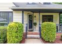Close-up of home's entry featuring a cozy porch with decorative shrubbery and natural light at 1426 Cedar Branch Ct, Wake Forest, NC 27587