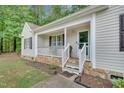 Inviting covered front porch with white railings and stone accents on the facade at 144 Shawnee Dr, Louisburg, NC 27549