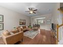 Open-concept living room with hardwood floors, ceiling fan, and dining area access at 158 Pineland Cir, Raleigh, NC 27606