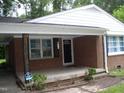 Inviting brick front porch with classic columns, offering a welcoming entrance to the home at 1809 S Garnett Ext, Henderson, NC 27536
