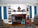 Cozy living room with a fireplace, hardwood floors, built-in bookshelves and natural light at 1809 S Garnett Ext, Henderson, NC 27536