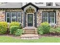 Close-up of front entrance featuring a decorative stone facade and trimmed landscaping at 205 Forest Hill Ave, Rocky Mount, NC 27804