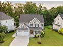 Beautiful aerial view of a landscaped home with a two-car garage and a large, green front lawn at 2083 Amalfi Pl, Apex, NC 27502