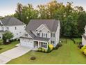 Aerial view of a gray home with a lawn, landscaping, and a two car garage at 2083 Amalfi Pl, Apex, NC 27502