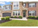 Up close view of a beautiful two story home with a well manicured lawn, stone and brick exterior at 2333 Lantern Walk Ln, Wake Forest, NC 27587