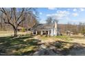 Charming front exterior featuring a covered porch with seating and a well-maintained lawn at 2710 Morton Pulliam Rd, Roxboro, NC 27574