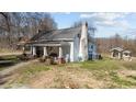 A side exterior shot of the house with a classic white exterior and well-maintained landscaping at 2710 Morton Pulliam Rd, Roxboro, NC 27574