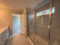 Bathroom featuring a glass enclosed shower with marble wall, a vanity, and an open doorway to bedroom at 285 Gregory Village Dr, Lillington, NC 27546