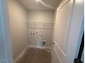 Compact laundry room featuring shelving and hookups for a washer and dryer at 285 Gregory Village Dr, Lillington, NC 27546