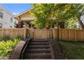 Yellow craftsman home with a fenced yard, brick stairs, and a welcoming front porch at 311 N Gregson St, Durham, NC 27701