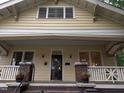 Close-up of a yellow craftsman home showing a covered front porch with brick posts at 311 N Gregson St, Durham, NC 27701