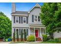 Charming two-story home with gray siding, black shutters, manicured landscaping, and a red front door at 3405 E Jameson Rd, Raleigh, NC 27604