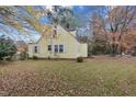 Charming yellow home featuring dormer windows, tidy landscaping, and a spacious grassy yard at 345 Henderson St, Oxford, NC 27565