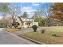 Inviting two-story yellow home featuring a spacious driveway and well-maintained landscaping and mature trees at 345 Henderson St, Oxford, NC 27565