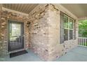 Close up on the brick exterior of a home with a glass paneled front door and porch at 4110 Argyle Trl, Burlington, NC 27215