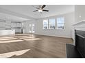 Bright and airy living room with wood floors, a modern fireplace, and large windows overlooking the backyard at 432 Golden Dragonfly St, Wake Forest, NC 27587