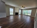 Inviting living room with a fireplace, wood-look flooring, and large windows that let in natural light at 4903 Bridgewood Dr, Durham, NC 27713