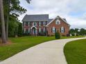 Elegant brick home featuring a long driveway and well-maintained landscaping at 5009 Beckwyck Dr, Fuquay Varina, NC 27526