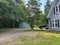 View of a side yard with gravel parking area and a detached garage at 509 W Rose St, Sanford, NC 27330