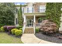 Welcoming front porch with stone steps, decorative plants, and a charming entrance at 5516 Colonial Oaks Dr, Apex, NC 27539