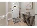 Bright foyer with a white front door, modern table, and light wood flooring at 629 Newlyn Dr, Raleigh, NC 27606