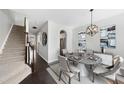 Elegant dining room with modern light fixture, stylish furnishings, and staircase for a sophisticated ambiance at 684 Wickham Ridge Rd, Apex, NC 27539