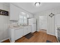 Well-lit kitchen with white cabinetry, wood floors, and modern appliances at 808 Ravenwood Dr, Raleigh, NC 27606