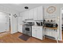 Well-lit kitchen with stainless steel appliances and white cabinetry. Appliances and decor included at 808 Ravenwood Dr, Raleigh, NC 27606