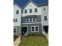 Three-story townhome with vertical siding and a neatly landscaped front yard at 809 Hyperion Aly, Wake Forest, NC 27587