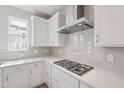 Modern kitchen features sleek stainless steel range hood and gas cooktop at 809 Hyperion Aly, Wake Forest, NC 27587