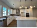 Beautiful kitchen features a center island, modern lighting, and stainless steel appliances at 809 Hyperion Aly, Wake Forest, NC 27587