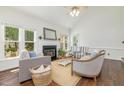 Open concept living room with a fireplace, hardwood floors, large windows and neutral paint at 8913 Walking Stick Trl, Raleigh, NC 27615