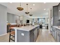 Modern kitchen features an island, quartz countertops, pendant lighting and stainless steel appliances at 10011 Secluded Gdn Dr # 169, Apex, NC 27523